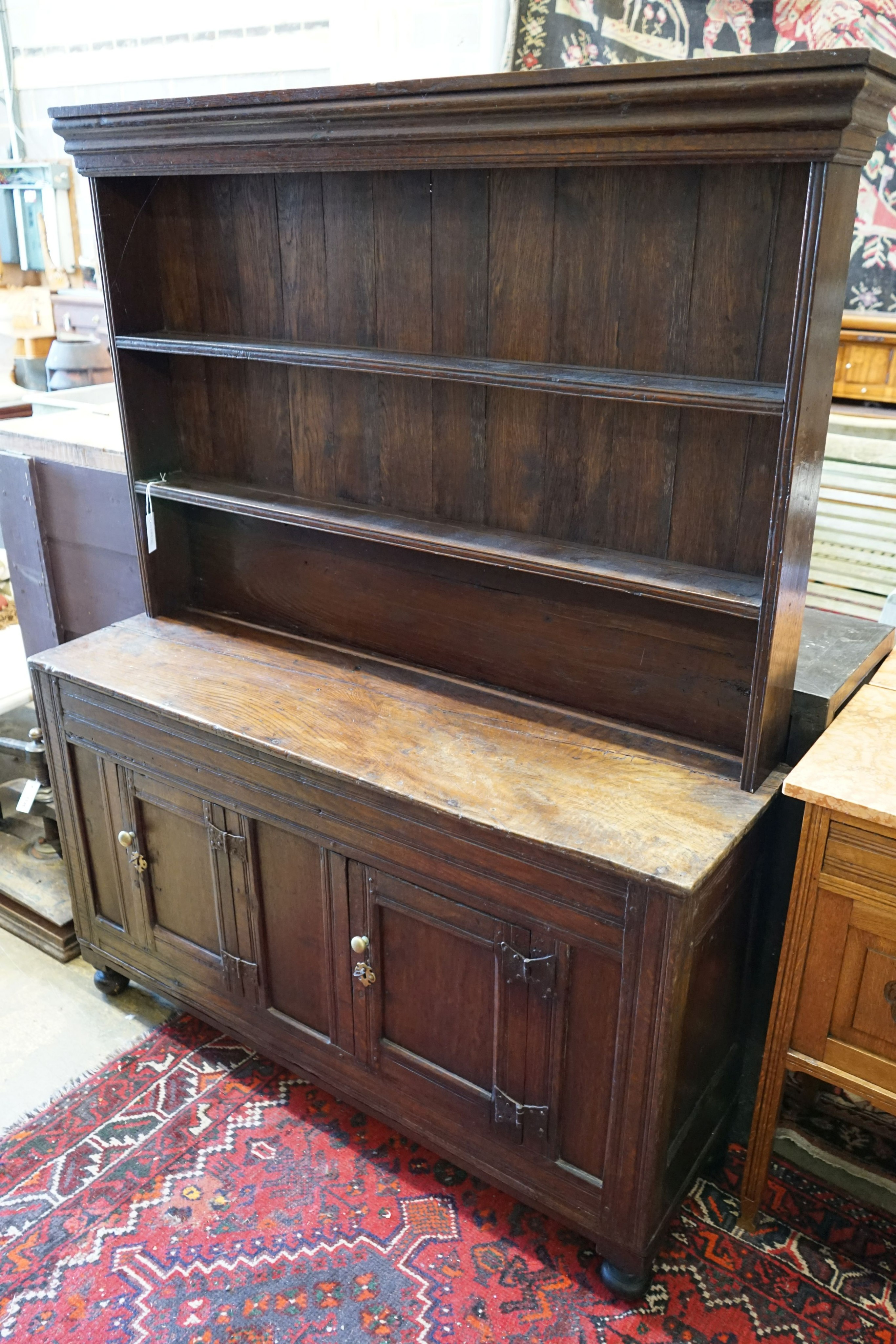 A 18th century and later small oak dresser with boarded rack, width 127cm depth 38cm height 166cm